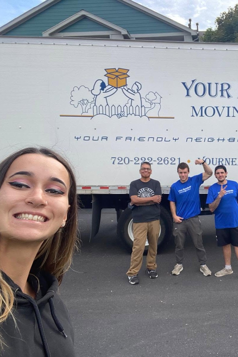Happy customer and moving crew beside a Your Neighbors truck